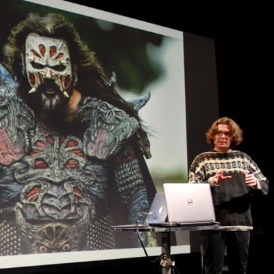 Antti Haase kertoo Monsterimies-elokuvastaan, taustalla Lordin kuva