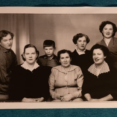 50-luvun valokuvassa poseeraa äiti kuuden lapsensa kanssa. Viisi tytärtä näyttävät aikuisilta, poika on näitä selvästi nuorempi.