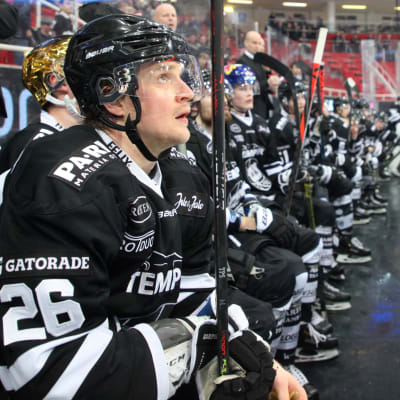 Lauri Korpikoski sitter på bytesbänken och tittar upp mot jumbotronen.