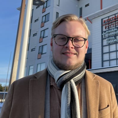 En ung man framför kommunhuset i Pyttis. 