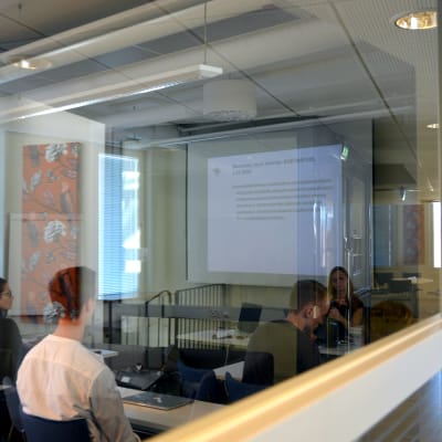 Studerande sitter i föreläsningssal. Fotat utifrån och bakifrån.