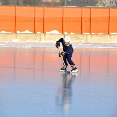 ett barn spelar ishockey