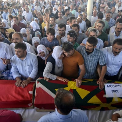 Släkt och vänner sörjer dem som dödades i en explosion i gränsstaden Suruc i Turkiet.