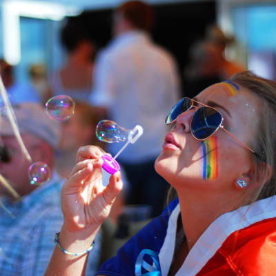 Michelle Wanström blåser såpbubblor inför starten till Åland Pride-paraden.