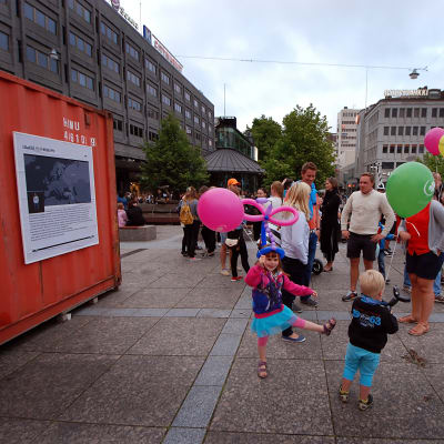 Barn med ballonger dansar utanför containern på Vasa torg.