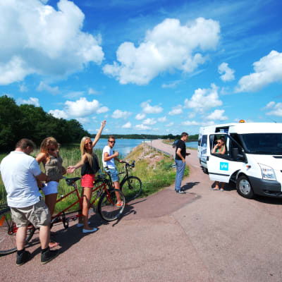 Forografen justerar en mikrofon i samband med att vi filmar cykling på Åland till En svensk sommar i Finland.