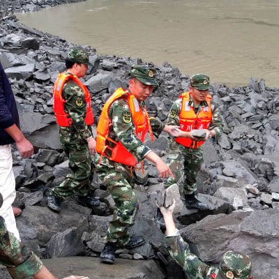 Räddningsarbetare letar efter överlevande bland stenblock i byn Xinmo, Sichuanprovinsen i Kina, efter jordskredet 24.6.2017