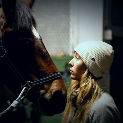 Emilia Soini talks to a horse.
