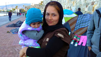 flyktingkvinna med ett barn i famnen