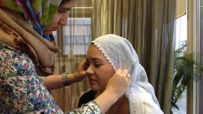 Sonila Naziri visar hur man knyter en hijab. Modellen är Anne-Lie Nyman.