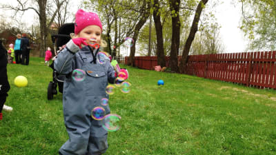 Barn blåser såpbubblor.