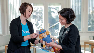 Presidentfrun Jenni Haukio tar emot en  Unicefdocka av Yvonne Korenius, ordförande för den frivilliga UNICEF-gruppen i Raseborg.