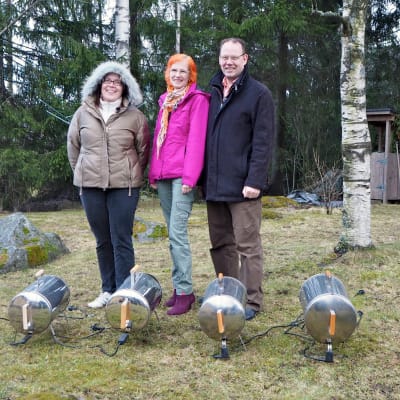 Kolme testaajaa ja savustimet nurmikolla.