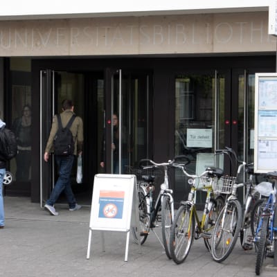 Människor utanför ingången till universitetet Erlangen i Tyskland. Vid universitetet Erlangen studerar för tillfället 4 600 utländska studeranden. De allra flesta av dem kommer från länder utanför EU.