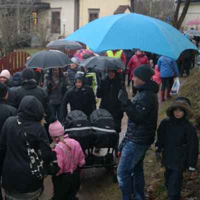 Folk i regnet i en smal gränd på Pargas julmarknad