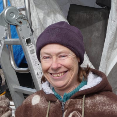 Riitta Airos framför sin intäckta segelbåt. I sommar väntar äventyret.