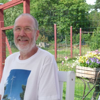 Janne Gröning sitter ute i sin trädgård i Keistiö i Iniö