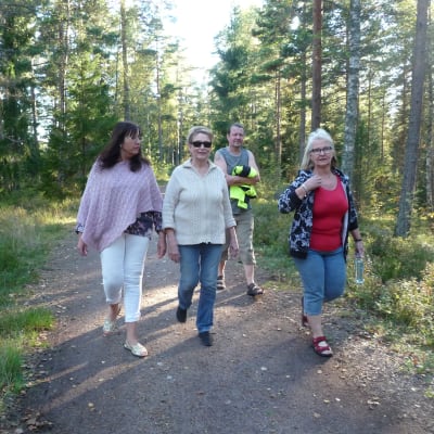 Synnöve Lindholm, Karin Svahnström, Mirja Koponen och hennes man Arto ute på promenad längs en spånbana i karis