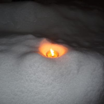 en marschall, stort värmeljus i en snödriva. Mörkt ute
