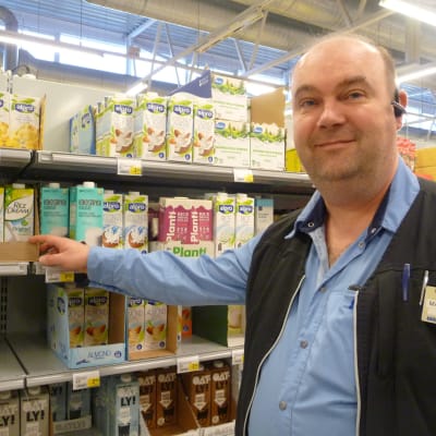 Marketschef Mika Gabrielsson står vid en butikshylla med växtmjölk.
