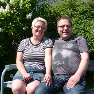 Anneli Heikkilä-Nordmyr och hennes man Mikael Nordmyr sitter på en bänk på en gård i Vasa.