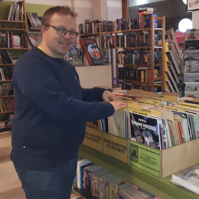 Antikvariaattikauppias Pekka Räsänen selailee sarjakuvia.