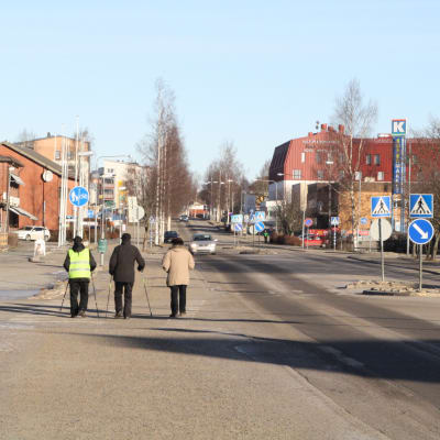 Tre män går längs med huvudgatan i Närpes.