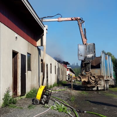 Lastbil utanför ett brinande svinhus.