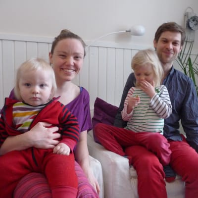 Familjen Lindström-Lindqvist i en soffa. På bild finns föräldrarna Victoria och Jon samt två barn i ålder ett till fyra år.