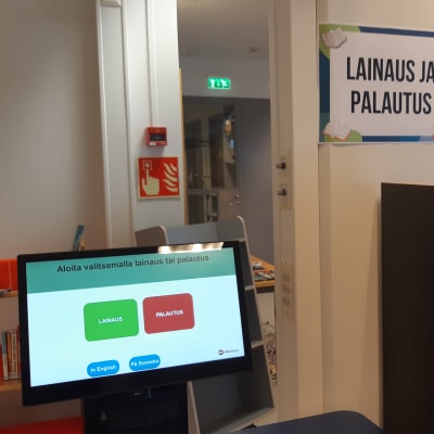 Kemin kaupunginkirjaston lainaus- ja palautusautomaatti. Vieressä hylly, jossa puolentusinaa palautettua kirjaa.