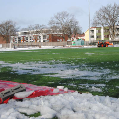En fotbollsplan täckt av is och snö.