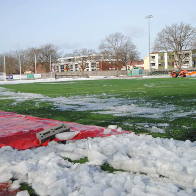 En fotbollsplan täckt av is och snö.