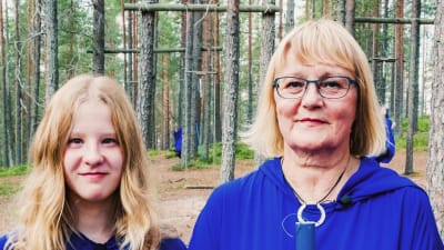 Anna-Liisa Helttunen ja Linnea Säisä pukeutuneina sinisiin kaapuihin ja toimittajat Nicke Aldén ja Hannamari Hoikkala Suomussalmen Soivassa Metsässä.
