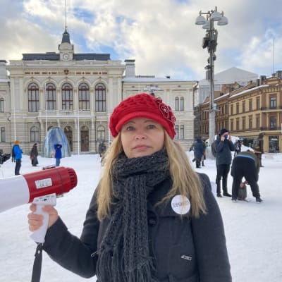Emmi Liinalaakso pitelee megafonia Tampereen Keskustorilla. Takana näkyy paikalle kokoontuvia mielenosoittajia.
