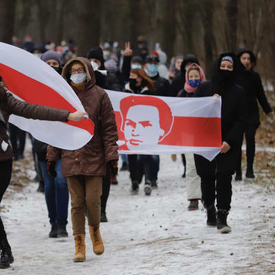 Demonstranter i Minsk bär svart-röda flaggor.