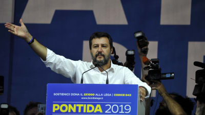 Matteo Salvini håller tal och sträcker ut handen.