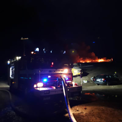 Brandbil framför ett brinnande berg av bildäck vid Jakobstads gamla avstjälpningsplats.