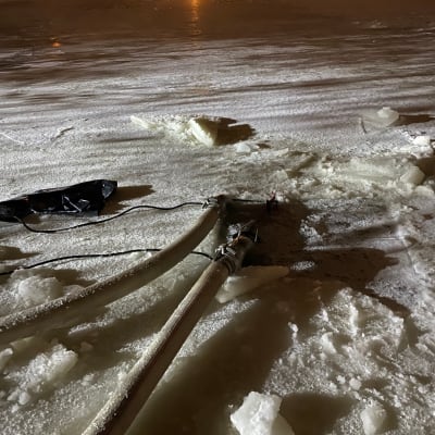Väliaikainen vesiputki Lielahden kaasuvoimalaan. Jäähdytysvettä letkulla avannosta.