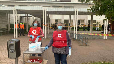 Frivilliga från Röda korset tar emot passagerare från M/S Amorella vid ett evakueringscenter på Strandnäs skola i Mariehamn 20.9.2020
