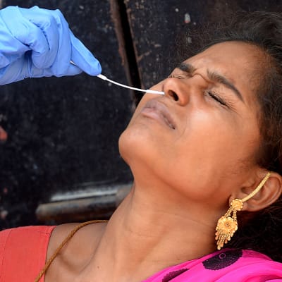 En indisk kvinna testas för coronaviruset.