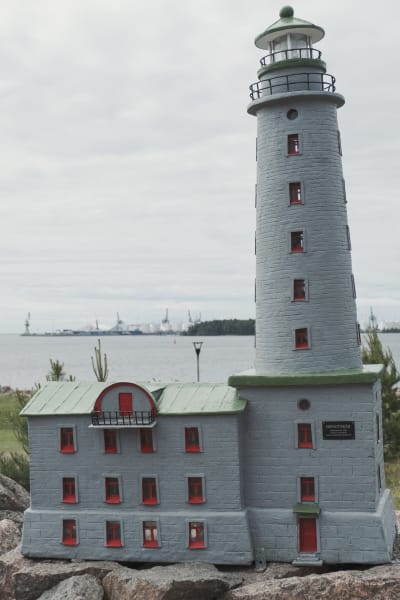 Bengtskärs fyr i miniatyr på en klippa, i bakgrunden havet. 