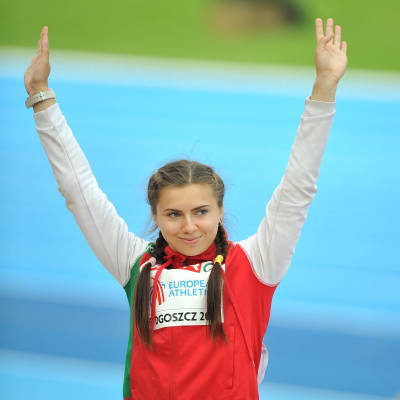 Kristina Timanovskaja håller upp händerna och hälsar medan hon ler.