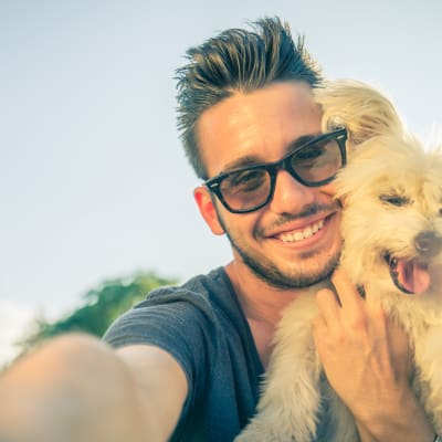 En man tar en selfie med sin hund. 