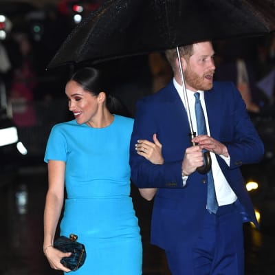 Meghan ja Harry hymyilevät sateenvarjon alla