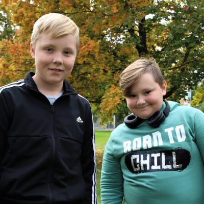 Oliver Svarvar och Melvin Nordman tittar in i kameran. Höstlöv i bakgrunden.