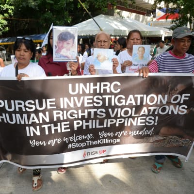 Släktingar till offer i kriget mot droger håller porträtt av sina släktingar under en minnesstund på den filippinska mänskliga rättighetskommissionen i Manila den 9 juli 2019.