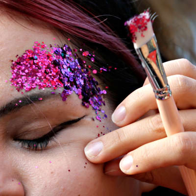 Naisen kasvoille tehdään glitter-meikkiä Serbian Belgradissa 18. syyskuuta 2021.