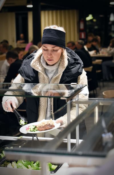 Erika Jänkä lastar mat på sin tallrik.