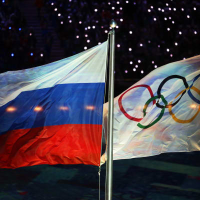 Den ryska flaggan svajar bredvid den olympiska flaggan.