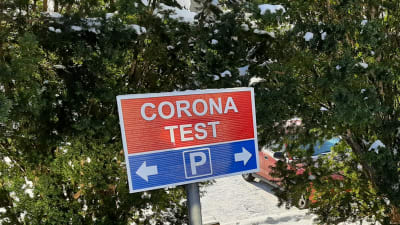 En rödblå skylt i snön meddelar att man får parkera här då man kommer för coronatest.